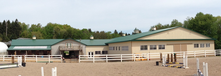 Rear view of new arena and clubhouse attached to existing stall barn