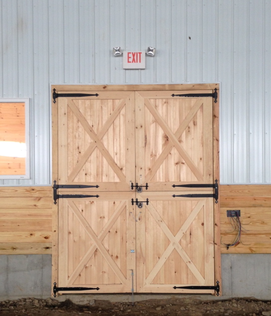 Wooden double doors at walkway leading to stall barn