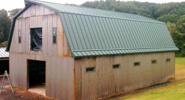 This 2-story pole barn has a Gambrel style roof and measures 40ft wide x 60ft long. The 1st floor has a 12ft ceiling, with the 2nd floor ceiling being 14ft at its highest point.  Features: -Designed to accommodate five 12ft x 12ft horse stalls, with room for a wash bay, tack-room and clubhouse. -Enclosed 36in wide stairway to 2nd floor -Standing-seam metal roof with vapor barrier and insulation -12x10 doorway at each gable end and a 8x8 loft door on 2nd floor with functional pulley hoist  -22-gauge corrugat
